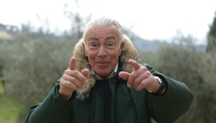 Senior man smiling and pointing fingers towards camera