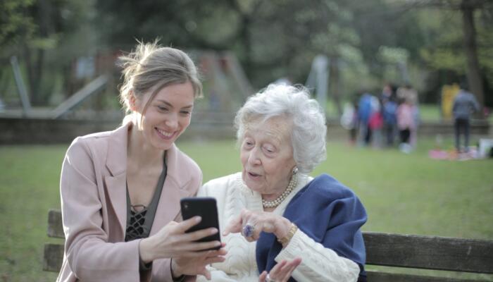 Two people on a park bench looking at a phone